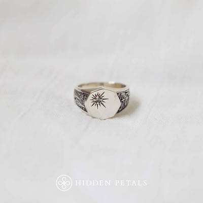 Hidden Petals' original design, a silver signet ring with a small star set with a white cubic zirconia. The ring band consist of carvings of the pine trees with shooting stars in the night sky.